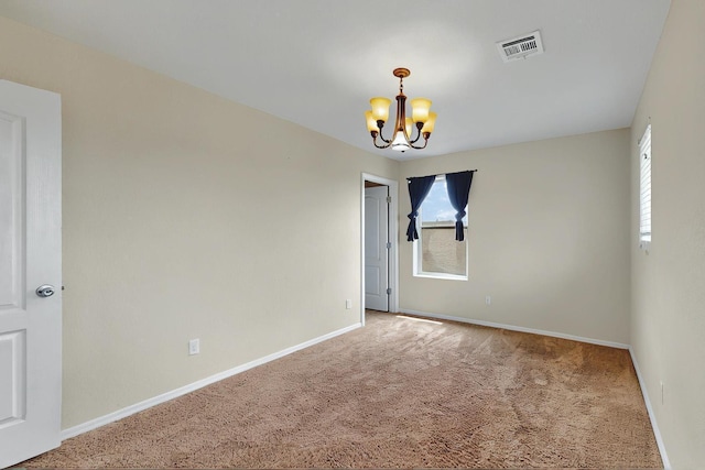carpeted empty room featuring visible vents, baseboards, and a notable chandelier