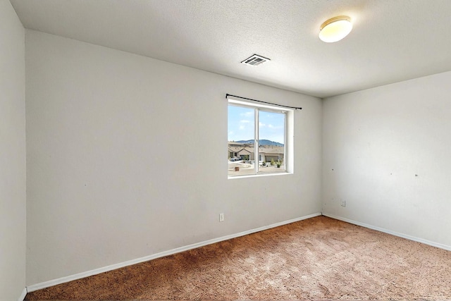 carpeted empty room featuring baseboards and visible vents