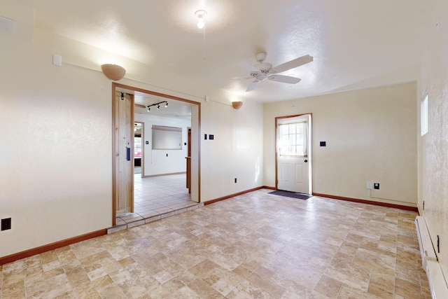 empty room with a ceiling fan and baseboards