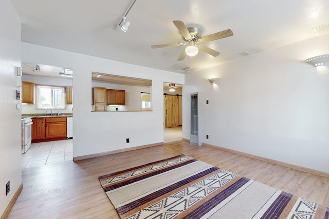 living area with light wood finished floors, baseboards, a ceiling fan, and rail lighting