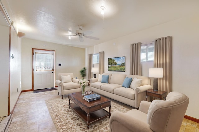 living area featuring baseboards and a ceiling fan