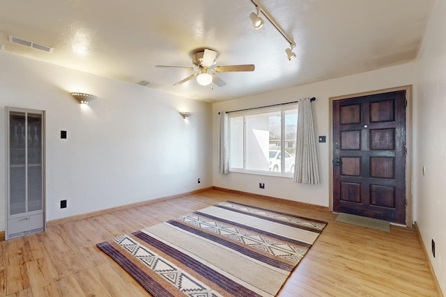 entrance foyer featuring baseboards, light wood-style flooring, visible vents, and a ceiling fan