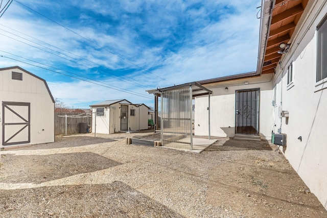 view of yard with a patio area, an outdoor structure, a storage shed, and fence