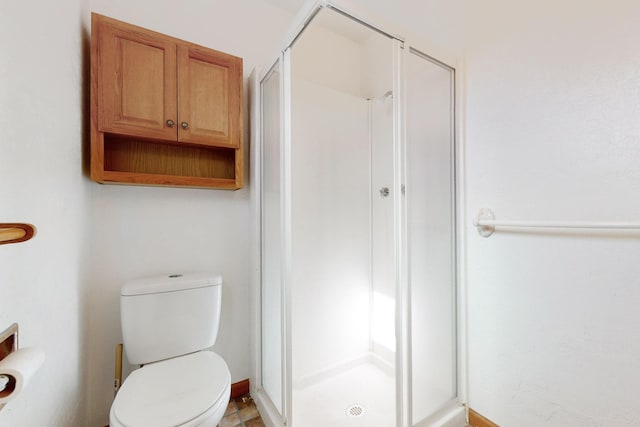 bathroom with a shower stall and toilet