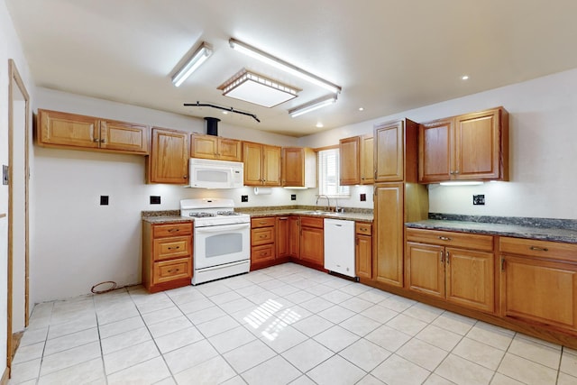 kitchen featuring brown cabinets, light tile patterned floors, recessed lighting, a sink, and white appliances