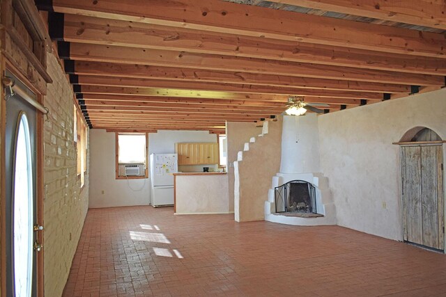 unfurnished living room featuring cooling unit and ceiling fan