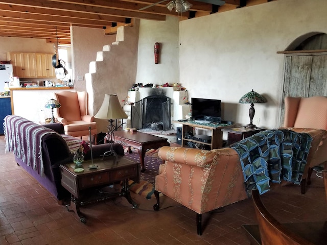 living room featuring ceiling fan and beamed ceiling