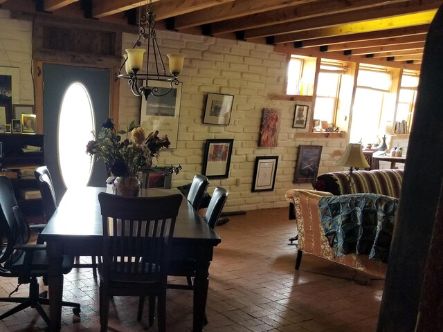 dining space with beamed ceiling and an inviting chandelier