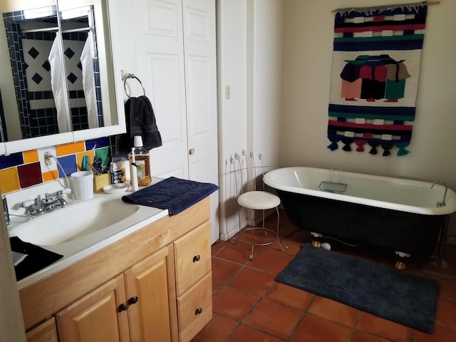 bathroom with a bathing tub, vanity, and tile patterned floors