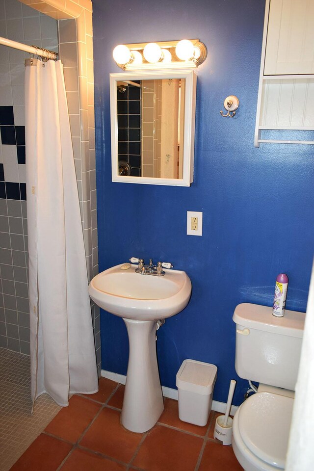 bathroom featuring tile patterned flooring, curtained shower, and toilet