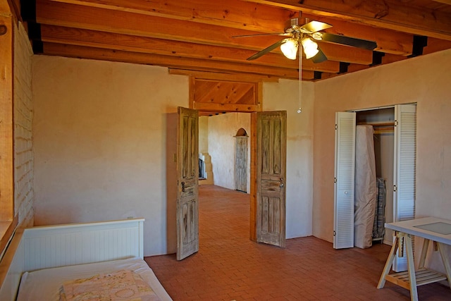 bedroom with radiator, beam ceiling, a closet, and ceiling fan