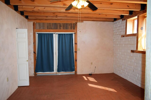 empty room featuring beamed ceiling and ceiling fan