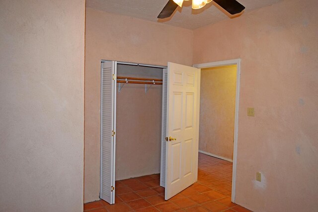 unfurnished bedroom featuring light tile patterned floors, a closet, and ceiling fan