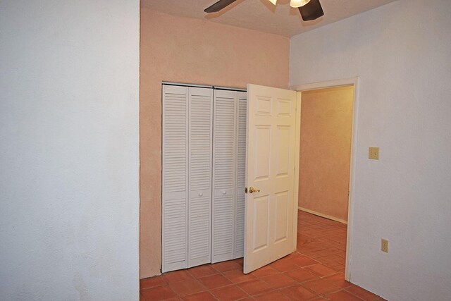 unfurnished bedroom featuring light tile patterned flooring, ceiling fan, and a closet