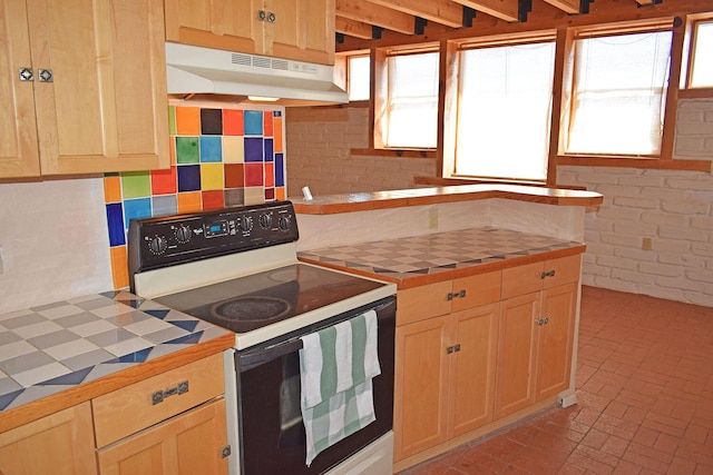 kitchen featuring range with electric cooktop, tile counters, and backsplash