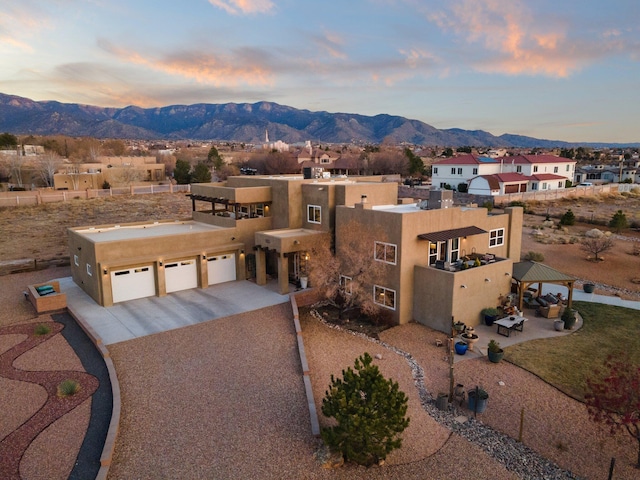 aerial view at dusk featuring a mountain view