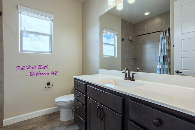 bathroom with hardwood / wood-style flooring, toilet, vanity, and curtained shower