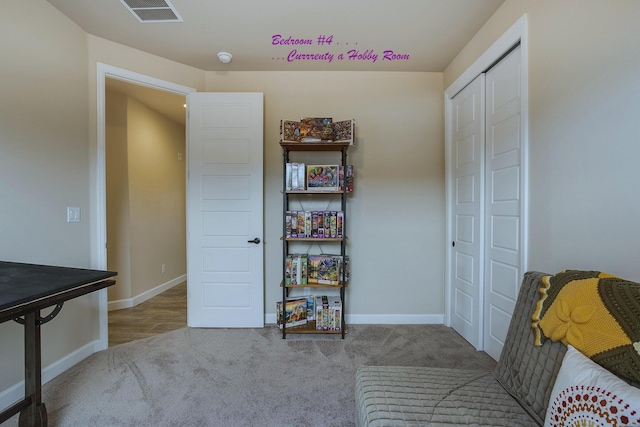 sitting room featuring a closet and light colored carpet