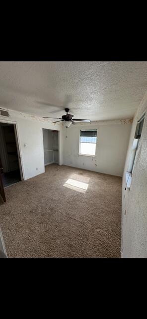 10613 Benavides Rd SW, Albuquerque, NM 87121 - unfurnished living room featuring carpet floors and a ceiling fan