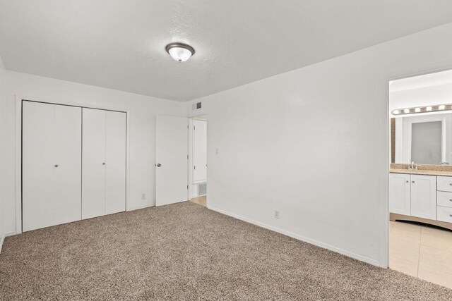 1613 Del Monte Trl SW, Albuquerque, NM 87121 - unfurnished bedroom featuring a closet, connected bathroom, sink, and light carpet