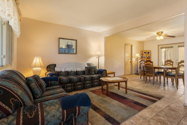 tiled living area featuring ceiling fan and french doors