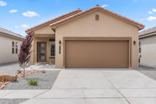 view of front of house with a garage, driveway, and stucco siding