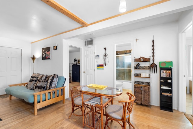 dining area featuring beam ceiling and light hardwood / wood-style floors