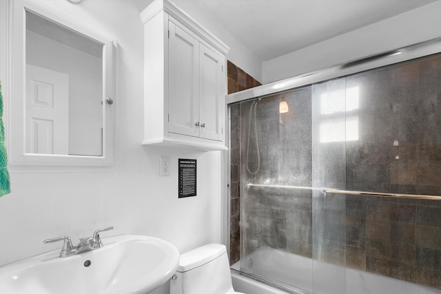 full bathroom featuring combined bath / shower with glass door, sink, and toilet