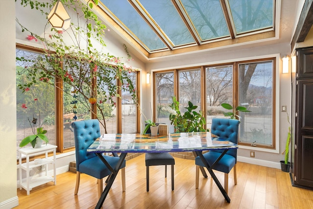 sunroom / solarium featuring lofted ceiling with skylight and plenty of natural light