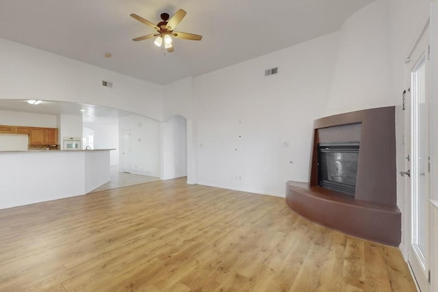 unfurnished living room featuring ceiling fan and light hardwood / wood-style floors