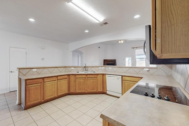 kitchen featuring sink, backsplash, black electric stovetop, white dishwasher, and kitchen peninsula