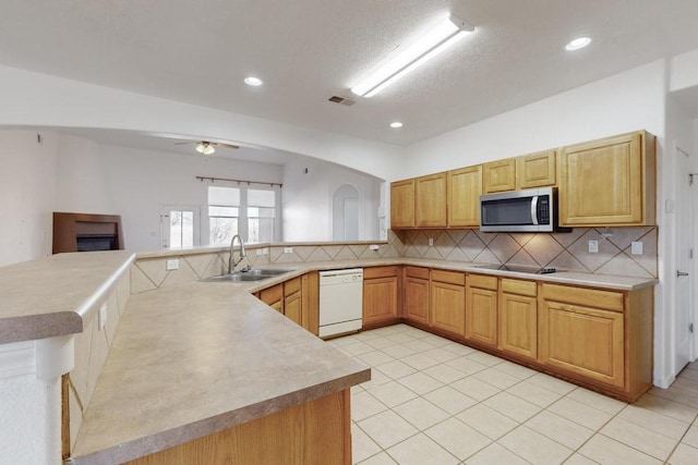 kitchen with sink, tasteful backsplash, white dishwasher, kitchen peninsula, and ceiling fan