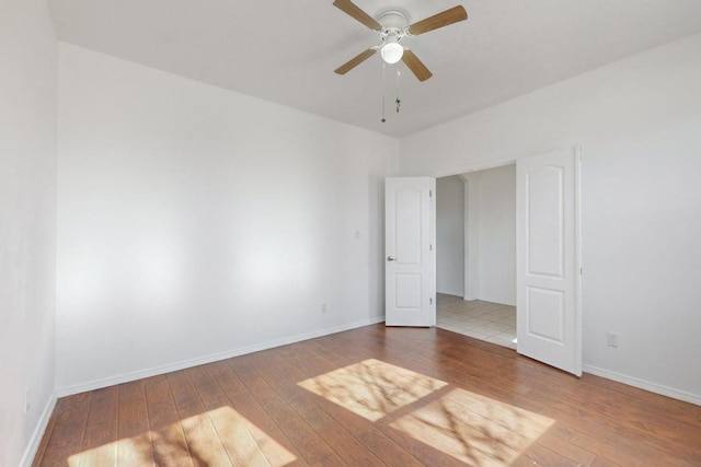 spare room featuring wood-type flooring and ceiling fan