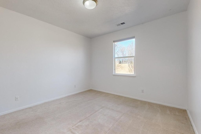 empty room with light carpet and a textured ceiling