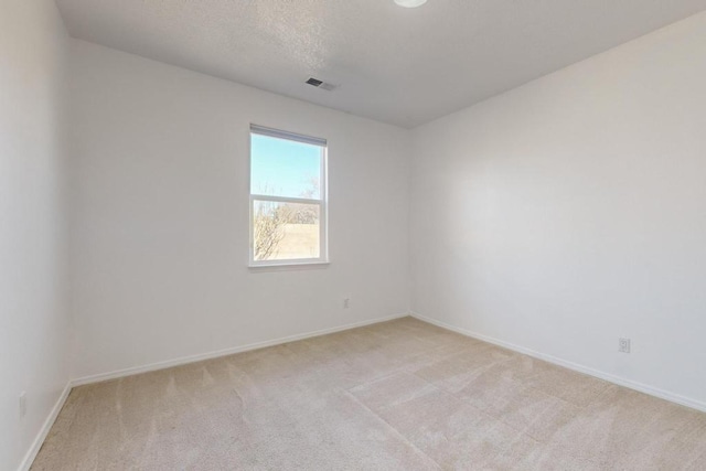 carpeted empty room with a textured ceiling