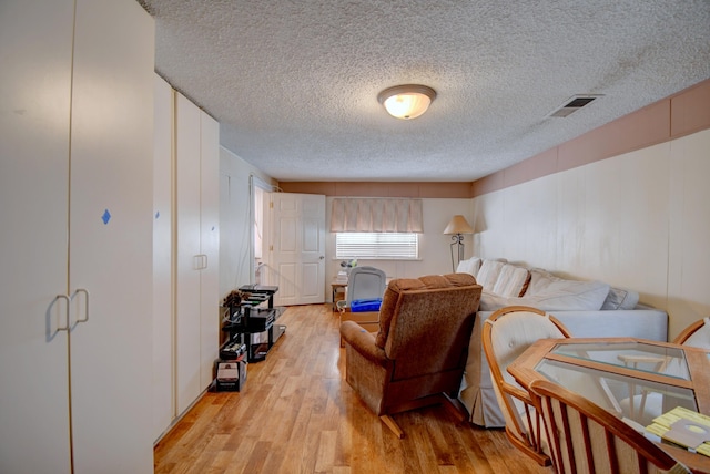 living room featuring a textured ceiling and light wood-type flooring