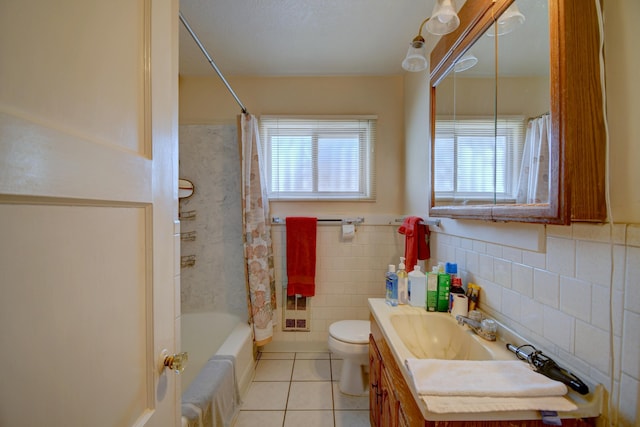 full bathroom featuring vanity, a healthy amount of sunlight, tile walls, and tile patterned floors