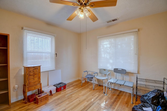 misc room featuring ceiling fan, light hardwood / wood-style floors, and a textured ceiling