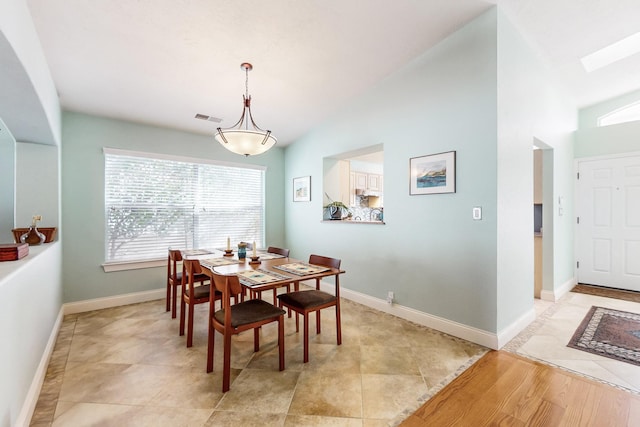 tiled dining space featuring lofted ceiling