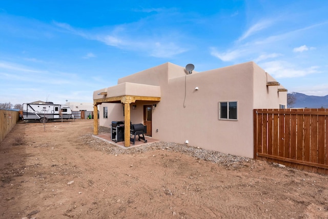 back of house with a mountain view and a patio area