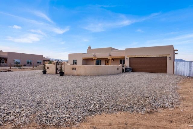 pueblo-style house featuring a garage