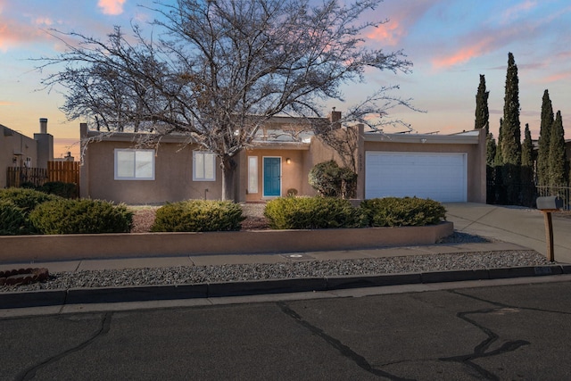 pueblo revival-style home featuring a garage