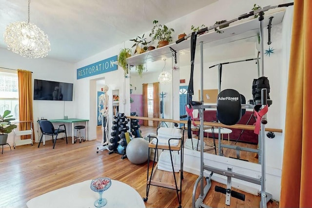 workout area with hardwood / wood-style flooring and a notable chandelier