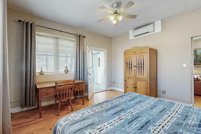 bedroom with ceiling fan, a wall unit AC, and light hardwood / wood-style flooring