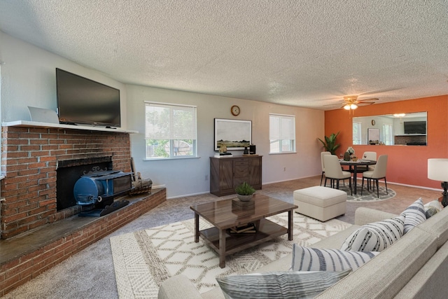 living room featuring ceiling fan, light colored carpet, and a textured ceiling