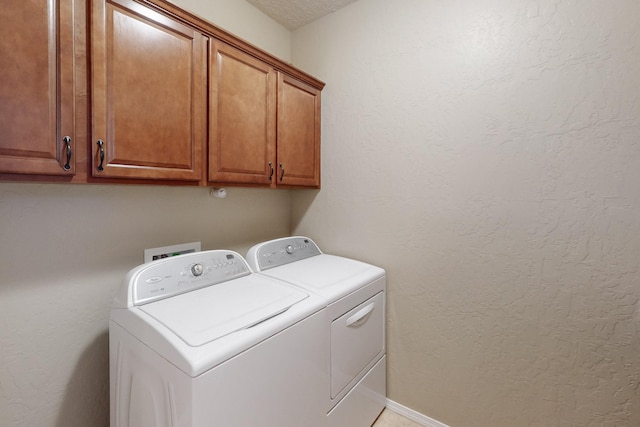 laundry room featuring separate washer and dryer and cabinets