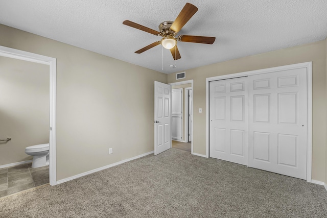 unfurnished bedroom with connected bathroom, carpet floors, ceiling fan, a textured ceiling, and a closet