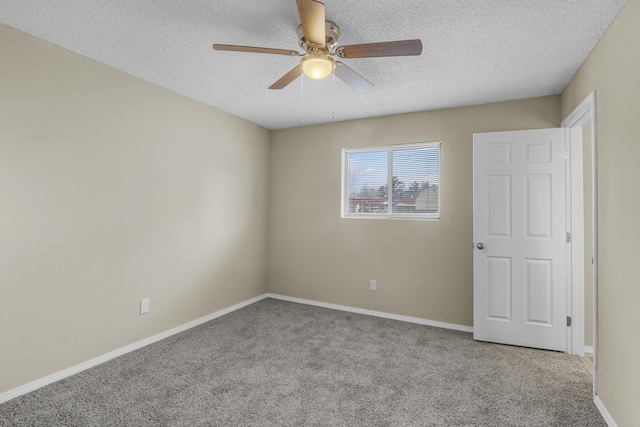 carpeted spare room with ceiling fan and a textured ceiling