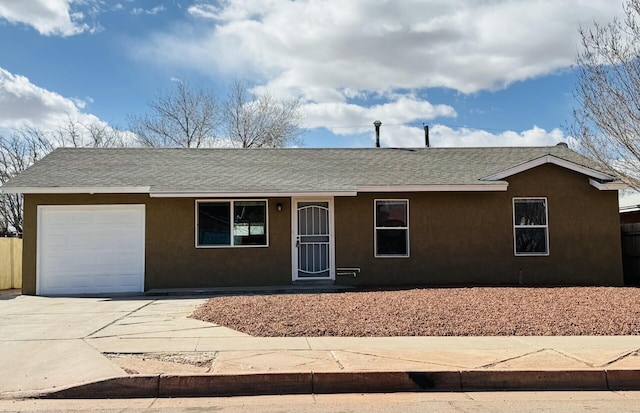 ranch-style home with concrete driveway, an attached garage, roof with shingles, and stucco siding