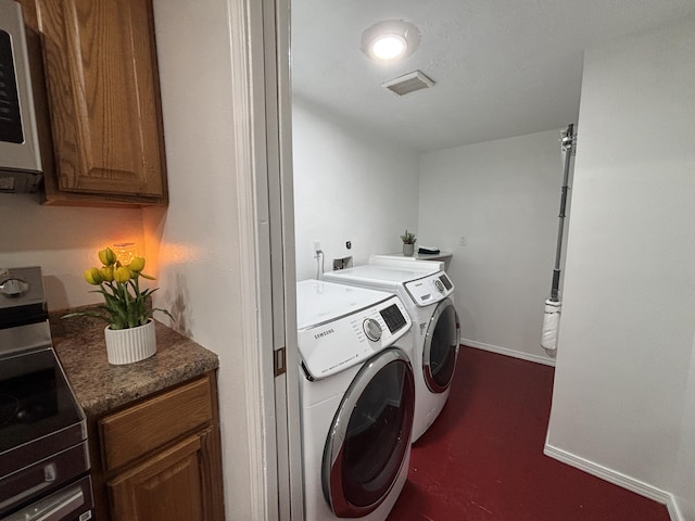 washroom with laundry area, baseboards, visible vents, and washer and clothes dryer